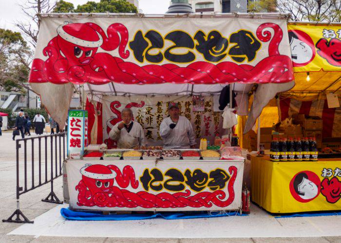 Two men working at a takoyaki yatai on the streets of Tokyo.